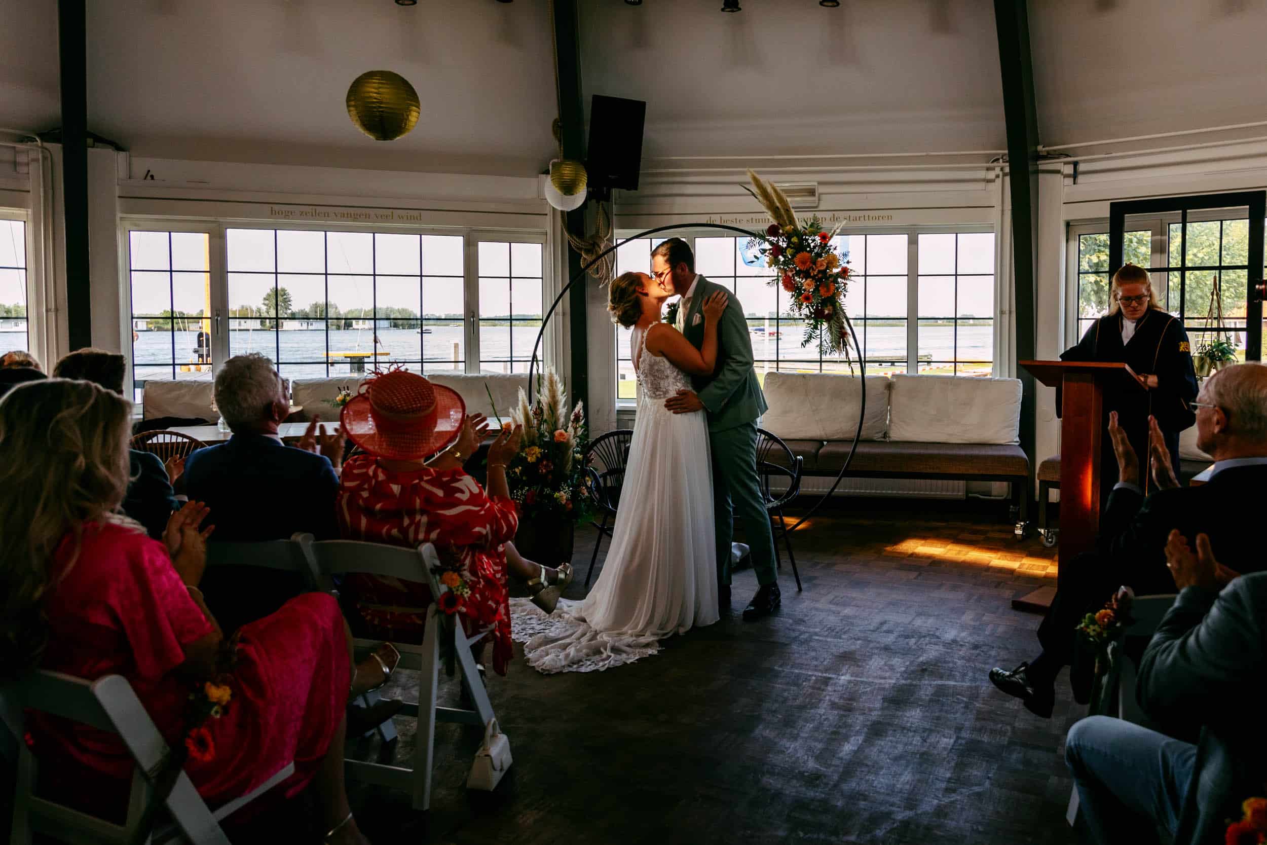Het perfecte bruiloftsmoment vastgelegd door een getalenteerde trouwfotograaf terwijl de bruid en bruidegom een kus delen tijdens hun ceremonie.