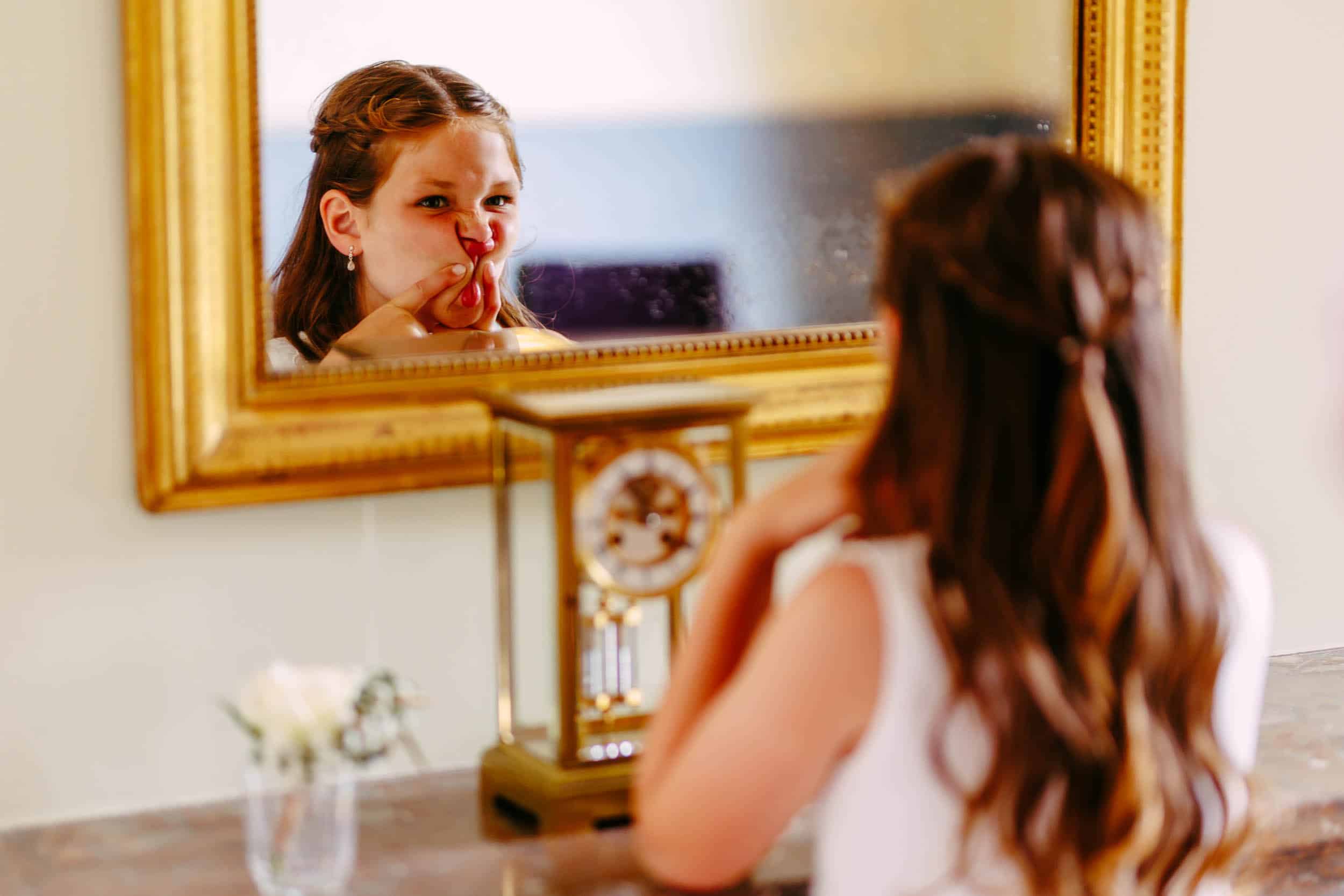 A girl looks at herself in a mirror.